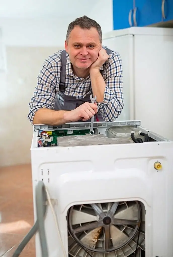 A friendly technician holding a wrench leans on a dismantled appliance, providing expert Fasteny dryer repair services.