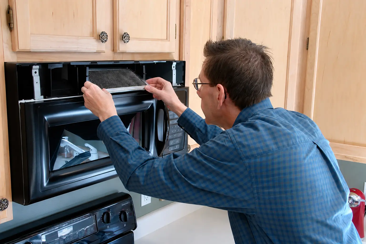 Professional appliance technician performing oven repair and maintenance service.