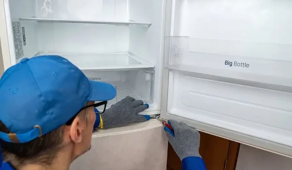 Fasteny Appliance Repair technician providing professional Refrigerator Repair service in a modern kitchen, diagnosing and fixing a broken refrigerator quickly and efficiently.